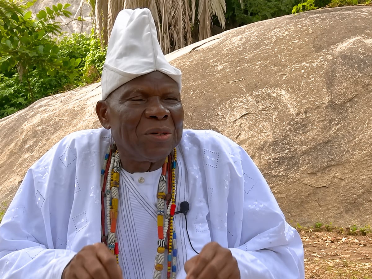 Maître Namousso en boubou blanc et colliers de perles traditionnels